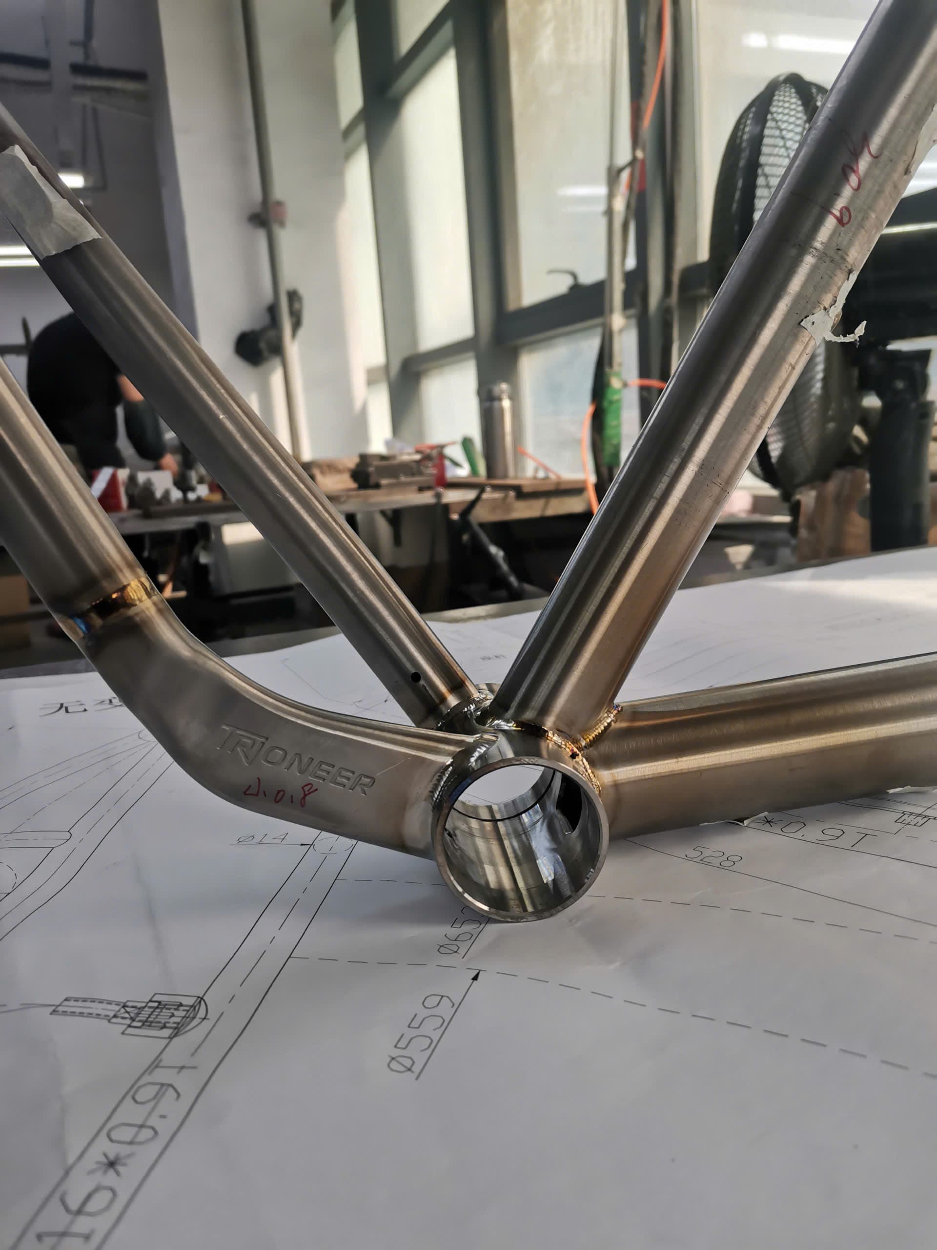 Frame builder inspecting a head tube weld